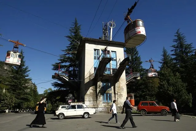 People pass a cable car station that is not running during a power cut in the town of Chiatura, some 220 km (136 miles) northwest of Tbilisi, September 12, 2013. (Photo by David Mdzinarishvili/Reuters)