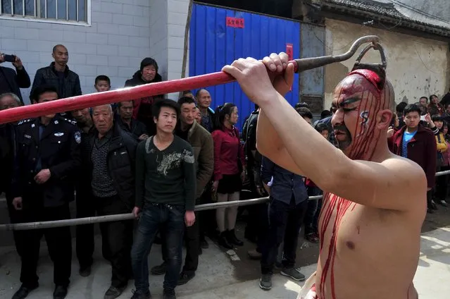 A folk performer (R) with make-up and props takes part in a “Blood Shehuo” parade, during a performance in Linyi county, Shanxi province March 21, 2015. (Photo by Reuters/Stringer)