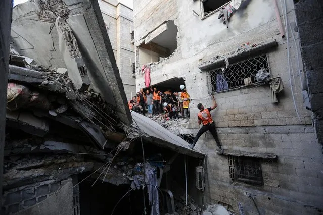 People search through buildings that were destroyed during Israeli air raids in the southern Gaza Strip November 1 2023 in Khan Yunis, Gaza. Entering the third week of the conflict, the Israeli army has expanded its military assault. The Gaza strip, a besieged Palestinian territory, is under heavy bombing from Israel in response to the large-scale attack carried out on October 7 by Hamas in Israel. The international community is stepping up pressure for a humanitarian truce.(Photo by Ahmad Hasaballah/Getty Images)