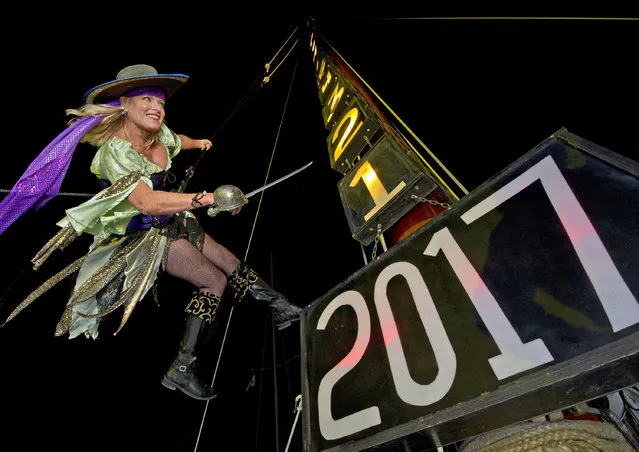 In this Friday, December 30, 2016, photo provided by the Florida Keys News Bureau, Evalena Worthington, costumed as a pirate wench, practices being lowered from the mast of the sailing vessel America 2.0 outside the Schooner Wharf Bar in Key West, Fla. Emotionally wrenching politics, foreign conflicts and shootings at home took a toll on Americans in 2016, but they are entering 2017 on an optimistic note, according to a new poll that found that a majority believes things are going to get better for the country next year. (Photo by Rob O'Neal/Florida Keys News Bureau via AP Photo)