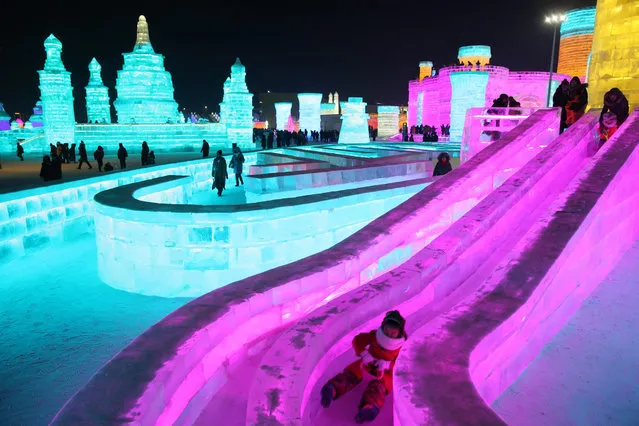 People visit the ice sculptures illuminated by coloured lights at Harbin ice and snow world for the 33rd Harbin International Ice and Snow Festival in Harbin city, China's northern Heilongjiang province, 05 January 2017. Some 180,000 cubic meters of ice and 150,000 cubic meters of snow were used to build the 800,000-square-meter Harbin ice and snow world where the festival will last for about three months. (Photo by Wu Hong/EPA)