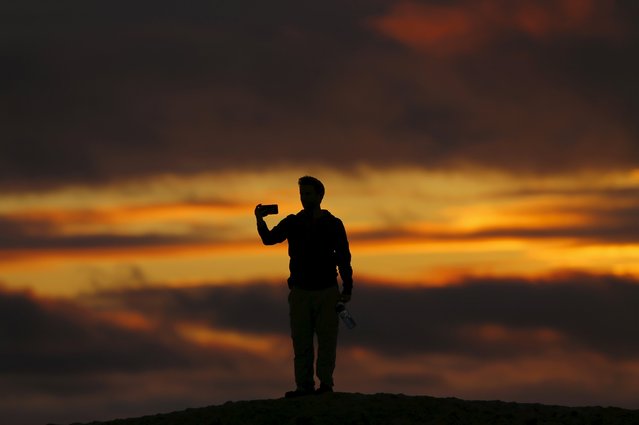 A man is silhouetted as he takes a selfie at sunset in Encinitas, California January 19, 2016. (Photo by Mike Blake/Reuters)