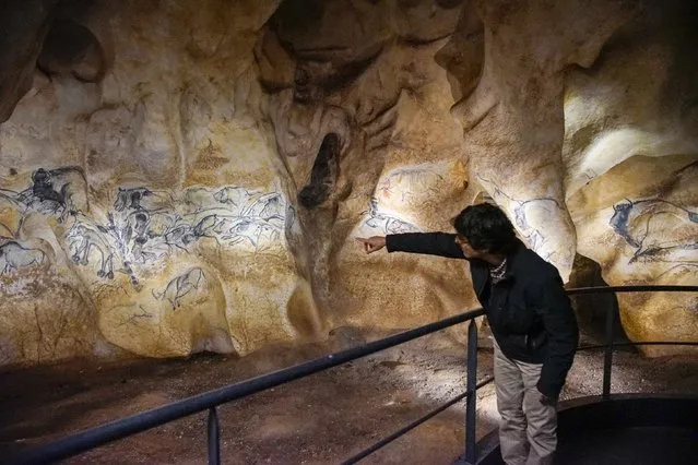 A visitor looks at a replica of pre-historic animals drawings seen on a wall during a press visit of the Cavern of Pont-d'Arc project site in Vallon Pont d'Arc April 8, 2015. (Photo by Robert Pratta/Reuters)