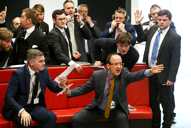 Traders, brokers and clerks shout and gesture on the trading floor of the open outcry pit at the London Metal Exchange (LME), at their new premises on Finsbury Square, in London, U.K in London, U.K., on Thursday, February 18, 2016. The new LME ring has capacity to host 14 members. (Photo by Chris Ratcliffe/Bloomberg)