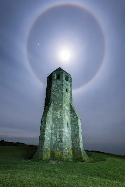 A picture of the moon surrounded by a halo of light on February 02, 2015 in Isle Of Wight, England. Jupiter is the brightest star on the left side of the halo. Isle of Wight based amateur photographer Ainsley Bennett captured this beautiful shot of the moon producing a strong halo at around midnight. The rings can be clearly seen in the high stratus clouds. Jupiter can be seen shining brightly to the left of the moon. (Photo by Ainsley Bennett/Barcroft Media)