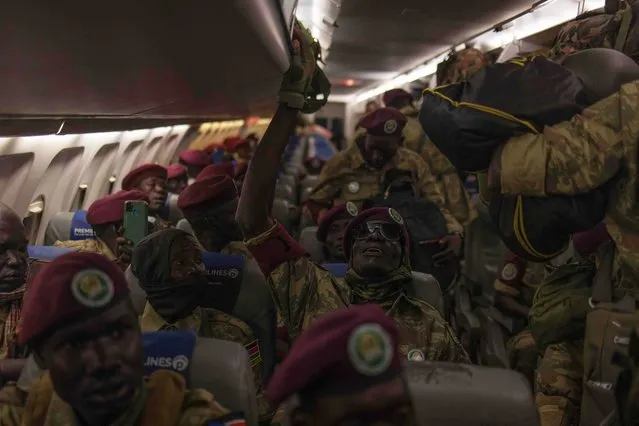 Members of the South Sudan People's Defence Force of the East African Community Regional Force (EAC-RF) sit on the plane before leaving the Democratic Republic of Congo at Goma airport on December 8, 2023. The East African Community (EAC) regional force began its withdrawal from the Democratic Republic of Congo in the morning of December 3 after Kinshasa deemed it ineffective and refused to renew its mandate. The regional bloc first deployed troops in the violence-plagued region in November last year after the resurgence of the M23 rebel group. (Photo by Guerchom Ndebo/AFP Photo)