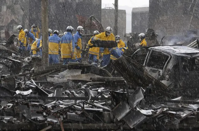 Police officers remove the debris from a fire at a market in Wajima, Ishikawa prefecture, Japan Saturday, January 6, 2024. A series of powerful quakes set off a large fire in the town of Wajima, as well as tsunamis and landslides in the region. (Photo by Kyodo News via AP Photo)