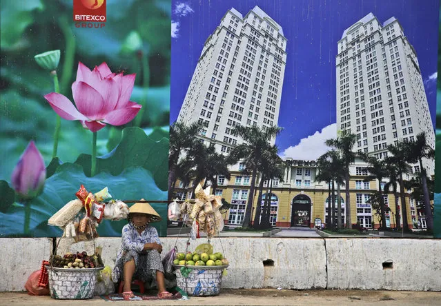 In this April 29, 2015, file photo, a snack and fruit vendor waits for customers near the advertisement board of a shopping mall and apartment building in Ho Chi Minh City, Vietnam. Vietnam, the location of U.S. President Donald Trump’s next meeting with North Korean leader Kim Jong Un, has come a long way since the U.S. abandoned its war against communist North Vietnam in the 1970s. (Photo by Dita Alangkara/AP Photo)