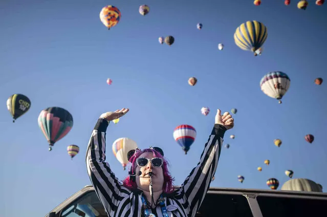 Launch Director Kat Brennan signals for a pilot to go ahead and take off Saturday, October 7, 2023, during the Albuquerque International Balloon Fiesta in Albuquerque, N.M. (Photo by Roberto E. Rosales/AP Photo)