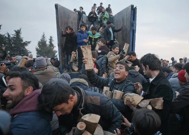 Migrants mob a truck bringing donated firewood at the northern Greek border station of Idomeni, Sunday, March 6, 2016. Greek police officials say Macedonian authorities have imposed further restrictions on refugees trying to cross the border, saying only those from cities they consider to be at war can enter as up to 14,000 people are trapped in Idomeni, while another 6,000-7,000 are being housed in refugee camps around the region. (Photo by Vadim Ghirda/AP Photo)