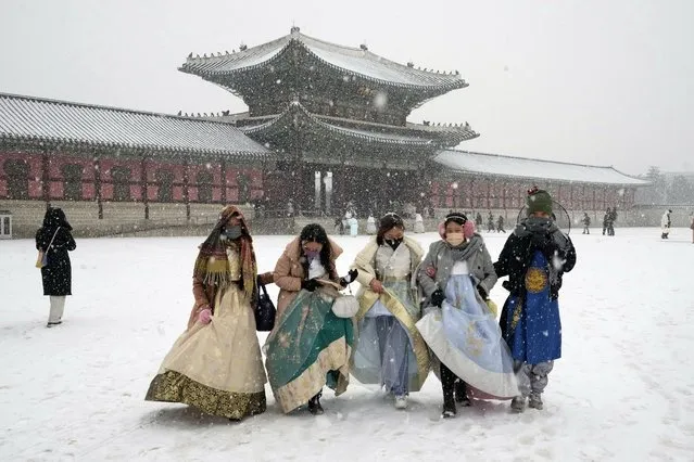 Visitors wearing traditional “Hanbok” costume in the snow walk through the Gyeongbok Palace, the main royal palace during the Joseon Dynasty, and one of South Korea's well known landmarks in Seoul, South Korea. Thursday, December 15, 2022. (Photo by Ahn Young-joon/AP Photo)