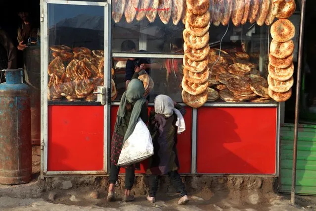 Afghan children buy breads from a bakery in Fayzabad of Badakhshan province on February 7, 2024. (Photo by Omer Abrar/AFP Photo)