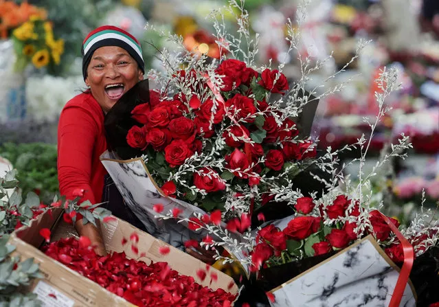 A vendor reacts as she poses for a photo at Adderley Street Flower Market on Valentine's Day, in Cape Town, South Africa, on February 14, 2024. (Photo by Esa Alexander/Reuters)