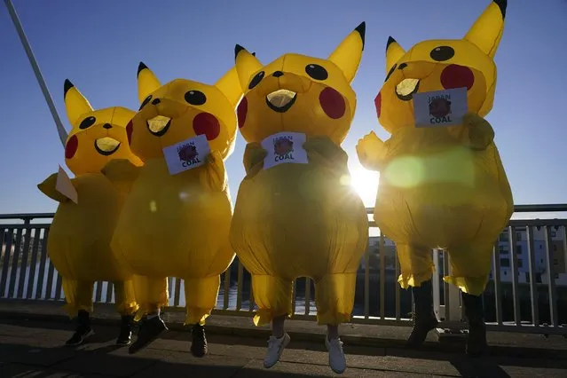 Activists dressed as the Pokemon character Pikachu protest against Japan's support of the coal industry near the COP26 U.N. Climate Summit in Glasgow, Scotland, Thursday, November 4, 2021. The U.N. climate summit in Glasgow gathers leaders from around the world, in Scotland's biggest city, to lay out their vision for addressing the common challenge of global warming. (Photo by Alberto Pezzali/AP Photo)