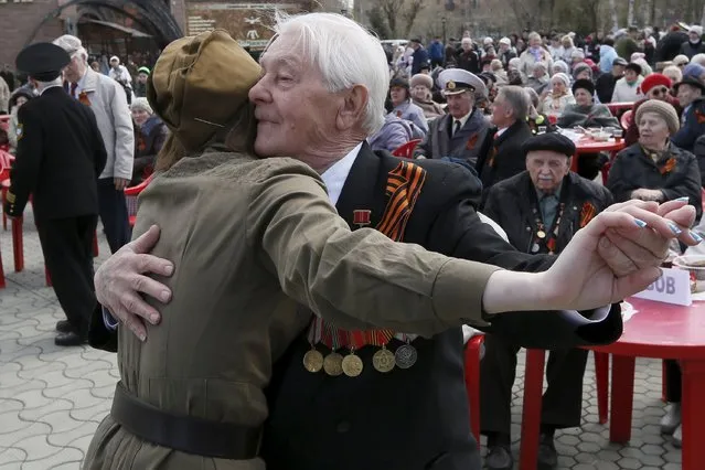 An elderly man dances with a girl dressed in a military uniform during a street performance to commemorate veterans of World War Two ahead of Victory Day in the centre of Russia's Siberian city of Krasnoyarsk, Russia May 5, 2015. Russia will celebrate the 70th anniversary of the victory over Nazi Germany in World War Two on May 9. (Photo by Ilya Naymushin/Reuters)