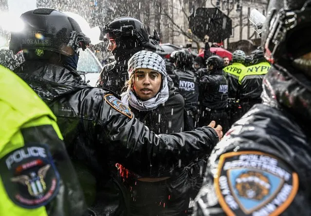 Police officers detain some pro-Palestinian protestors as people, holding banners and Palestinian flags, gather at Washington Square Park to protest against Israeli attacks on Gaza in New York, United States on March 02, 2024. (Photo by Fatih Aktas/Anadolu via Getty Images)