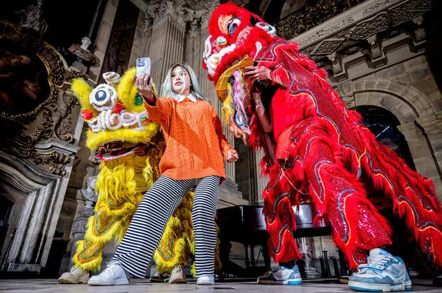 A visitor to Castle Howard in North Yorkshire in the last decade of January 2024 poses with dancers from York and Manchester wearing traditional costume to celebrate the Chinese New Year, which takes place next month. (Photo by Charlotte Graham/The Times)