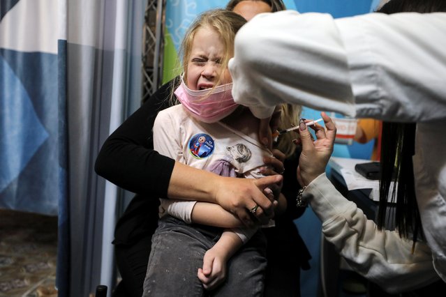 A girl receives her first coronavirus disease (COVID-19) vaccination after the country approved vaccinations for children aged 5-11, in Jerusalem on November 23, 2021. (Photo by Ammar Awad/Reuters)