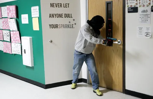 A student prepares to search a classroom in a middle school for a shooter during an Active Shooter Response course offered by TAC ONE Consulting in Denver April 2, 2016. According to TAC ONE, the course, which is offered for the first time to concealed weapons permit carrying civilians, is designed at preparing people to effectively save lives prior to the arrival of law enforcement at an active shooter incident. (Photo by Rick Wilking/Reuters)