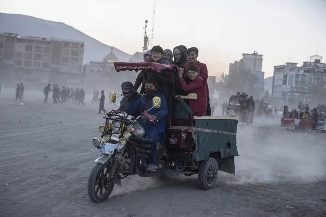 Spectators leave on a three wheel vehicle after watch wrestling matches in Kabul, Afghanistan, Friday, December 3 , 2021. (Photo by Petros Giannakouris/AP Photo)