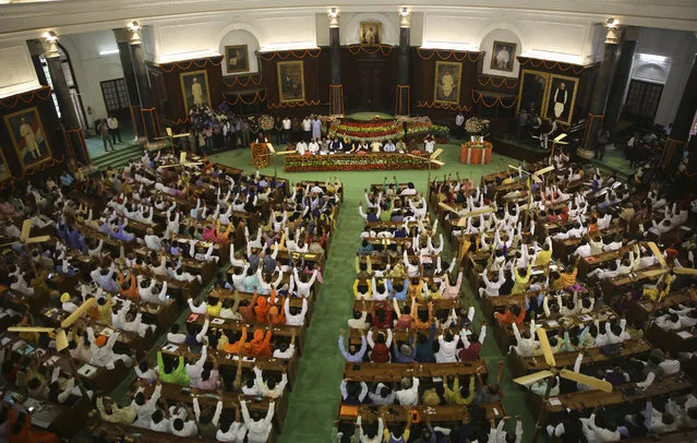 Newly elected lawmakers from India's ruling alliance led by the Hindu nationalist Bharatiya Janata Party raise their hands in support of Narendra Modi being elected their leader in New Delhi, India, Saturday, May 25, 2019. BJP president Amit Shah announced Modi's name as the leader of the National Democratic Alliance in a meeting of the lawmakers in the Central Hall of Parliament in New Delhi, paving the way for Modi's second five-year term as prime minister after a thunderous victory in national elections. (Photo by Manish Swarup/AP Photo)
