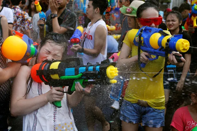 Revellers react during a water fight at Songkran Festival celebrations in Bangkok April 13, 2016. (Photo by Jorge Silva/Reuters)