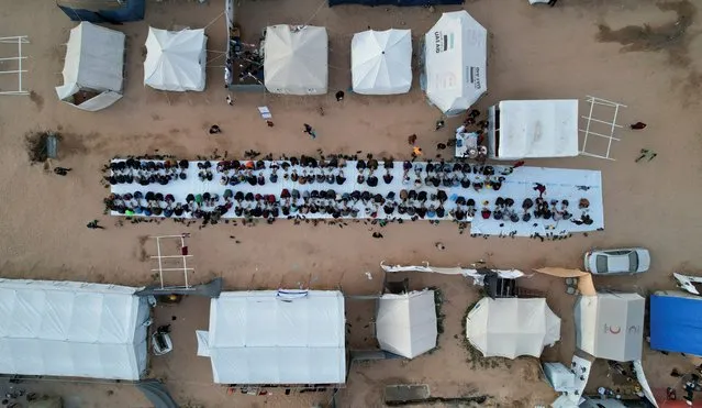 A drone view shows Palestinians, who were displaced by Israel's military offensive, gathering to have their Iftar (breaking of the fast) during the holy month of Ramadan, in Rafah in the southern Gaza Strip on April 6, 2024. (Photo by Shadi Tabatibi/Reuters)