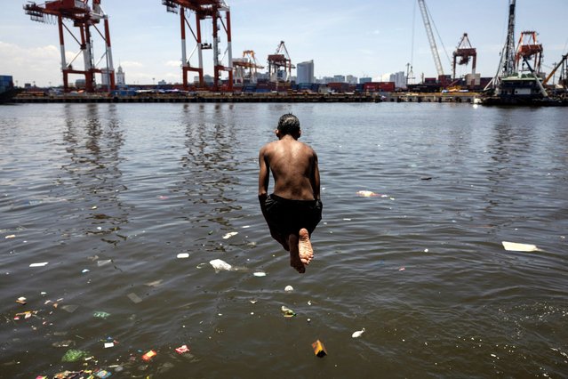 A boy jumps in the polluted waters of Baseco Beach during a hot day in Manila, Philippines, on April 25, 2024. (Photo by Eloisa Lopez/Reuters)