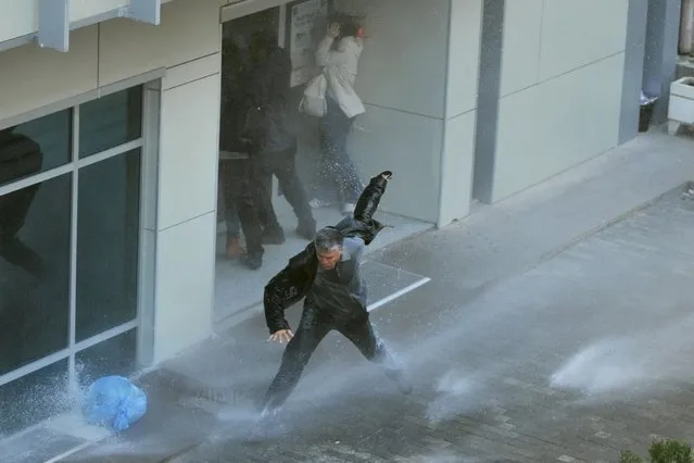 Turkish riot police use water cannon to disperse protesters outside the Supreme Electoral Council (YSK) in Ankara on April 1, 2014. Turkish police on April 1 deployed water cannon against protesters who alleged vote-rigging in weekend local polls in which the Islamic-rooted party of Premier Recep Tayyip Erdogan claimed sweeping victories. About 2,000 supporters of the main secular opposition party had massed outside the elections authority in the capital Ankara, chanting “Thief Tayyip!” and “Ankara, don't sleep. Stand up for your vote!” (Photo by Adem Altan/AFP Photo)