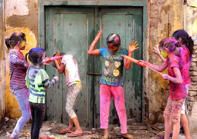 Indian revellers play with colours during Holi celebrations in Chennai on March 13, 2017. The Hindu festival of Holi, or the “Festival of Colours” heralds the arrival of spring and the end of winter. (Photo by Arun Sankar/AFP Photo)