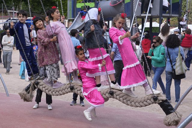 Children wearing regional “Chulapa” dress play on a swing during the San Isidro festivities in Madrid, Spain, Wednesday May 15, 2024. The festivities during the bank holiday are in honour of the patron saint of Madrid. (Ohiti by Paul White/AP Photo)