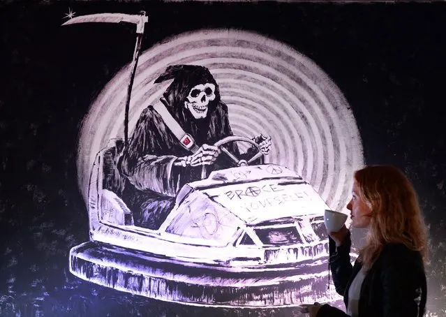 A woman looks over pseudonymous British graffiti artist Banksy's artwork “Brace Yourself” at the 'Stealing Banksy' exhibition in London, Britain, 24 April, 2014. The exhibition explores the social, legal and moral issues surround the sale of street art. (Photo by Andy Rain/EPA)
