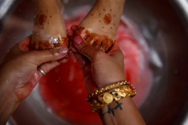The feet of a young girl dressed as the Living Goddess Kumari are washed during the Kumari Puja festival, in which young girls pose as the Living Goddess Kumari and are worshipped by people in belief that their children will remain healthy, in Kathmandu, Nepal on September 11, 2019. (Photo by Navesh Chitrakar/Reuters)