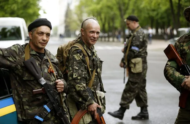 Armed pro-Russian activists stand near the seized regional government headquarters in Luhansk, eastern Ukraine, May 3, 2014. (Photo by Vasily Fedosenko/Reuters)