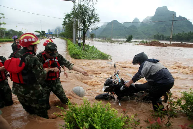 Rescuers help to pull a motorcycle at a flooded area after heavy rainfall in Guilin, Guangxi Zhuang Autonomous Region, China, May 8, 2016. (Photo by Reuters/Stringer)