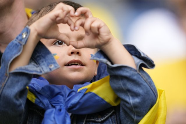 A Ukrainian child makes a heart sign ahead of a Group E match between Slovakia and Ukraine at the Euro 2024 soccer tournament in Duesseldorf, Germany, Friday, June 21, 2024. (Photo by Andreea Alexandru/AP Photo)