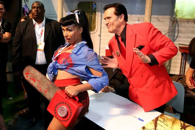 Bruce Campbell, right, poses with a fan during an autograph signing for the STARZ original series “Ash vs Evil Dead” at San Diego Comic-Con on Friday, July 10, 2015 in San Diego. (Photo by Matt Sayles/Invision for STARZ/AP Images)