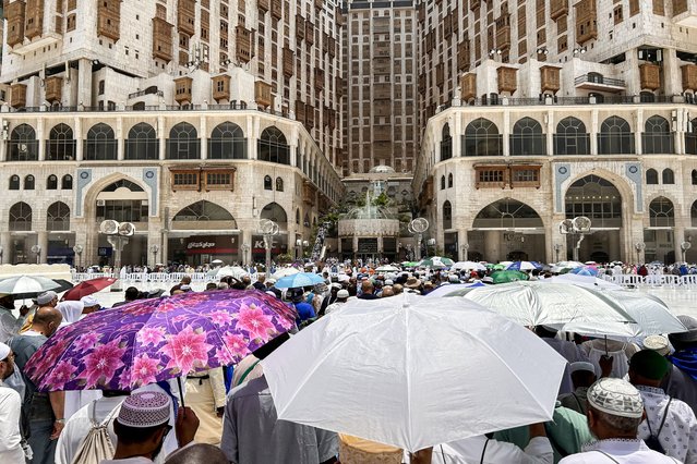 Muslim worshippers shade themselves with umbrellas as they walk near the Grand Mosque in Saudi Arabia's holy city of Mecca on June 13, 2024, ahead of the annual Hajj pilgrimage. (Photo by Fadel Senna/AFP Photo)