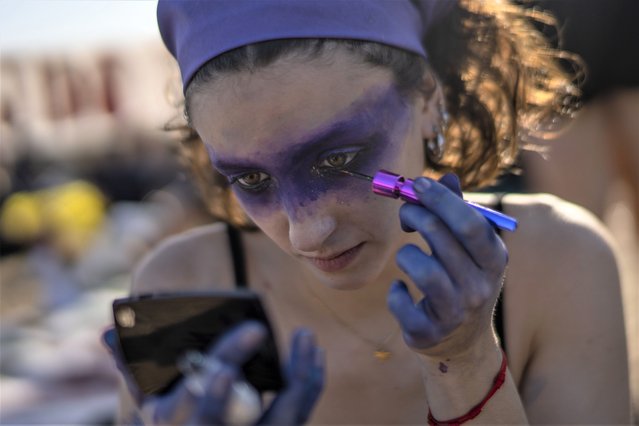 A woman prepares to participate in a rally to mark International Women's Day in Montevideo, Uruguay, Wednesday, March 8, 2023. (Phoot by Matilde Campodonico/AP Photo)