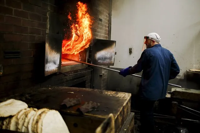 A worker of the Chareidim Shmurah Matzoh Bakery prepares matzoh bread for Jewish holidays at the Brooklyn borough of New York April 12, 2016. (Photo by Eduardo Munoz/Reuters)