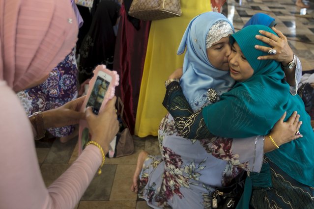Thai Muslim women hug each others after attending a mass prayer during Eid al-Fitr celebrations at a mosque in Bangkok, Thailand, July 17, 2015. (Photo by Athit Perawongmetha/Reuters)