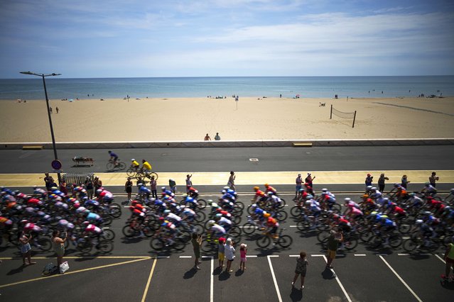 The pack rides the ceremonial parade along the Mediterranean Sea in Gruissan during the sixteenth stage of the Tour de France cycling race over 188.6 kilometers (117.2 miles) with start in Gruissan and finish in Nimes, France, Tuesday, July 16, 2024. (Photo by Daniel Cole/AP Photo)