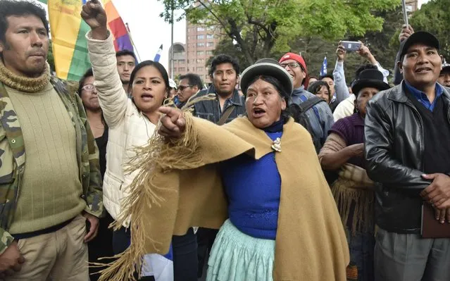 Supporters of Bolivia's president and candidate Evo Morales demonstrate against the main opposition candidate, former president (2003-2005) Carlos Mesa, as supporters of both groups gather outside the hotel where the Supreme Electoral Tribunal has its headquarters to count the election votes, in La Paz, on October 21, 2019. Evo Morales, seeking a controversial fourth term, led Bolivia's presidential election race Sunday but faces a historic second round run-off against opposition rival Carlos Mesa, partial results showed. Morales had 45 percent of the vote to Mesa's 38 percent, the Supreme Electoral Tribunal announced, with most of the votes counted. (Photo by Aizar Raldes/AFP Photo)