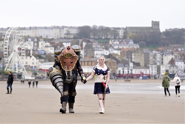 Bradley Calvert (left) and Georgina Donnalley (right) pose for a photograph dressed as characters from first-person shooter video game BioShock 2, as they walk along Scarborough beach during the Sci Fi Scarborough at The Spa Complex in Scarborough, United Kingdom on Sunday, April 23, 2023. (Photo by Danny Lawson/PA Images via Getty Images)