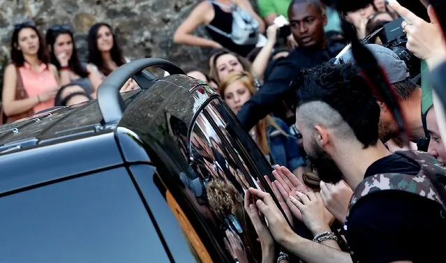 Fans gather near a car at Forte di Belvedere in Florence, on May 24, 2014. (Photo by Tiziana Fabi/AFP Photo)