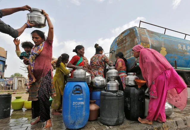 Local residents fill their empty containers with water from municipal corporation tanker on a hot summer day in Ahmedabad, India May 30, 2016. (Photo by Amit Dave/Reuters)