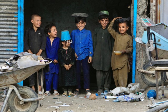 Afghan children stand at a scrap shop outside a World Food Program (WFP) distribution centre in Kabul, Afghanistan, on August 21, 2024. (Photo by Sayed Hassib/Reuters)