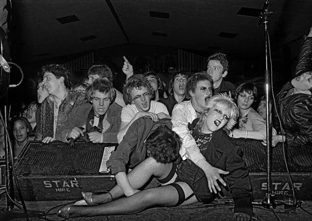 A stagecrashing punk in Norfolk, East Anglia. “I took this photograph at a Rock Against Racism gig in 1979. The Ruts were playing the West Runton Pavilion in Cromer, and it was rammed and really hot, but also really exciting. Everyone was pogoing and jumping up and down with their fists in the air – it was mayhem. I was near the front when I saw the girl climb up on to the stage and take up that reclining pose between two monitors. It was one of those adrenaline-driven moments when nothing matters apart from getting the shot. So I climbed over everyone’s heads and dragged myself on to the stage in front of the lead singer, Michael Owen. I had my two Nikons around my neck and a big old Norman flash and it just went pop. A second later I was in the air and then on my back in the middle of the audience. The bouncer had thrown me off the stage. I still have those cameras and one of them has a big dent from that night”. (Photo by Syd Shelton)