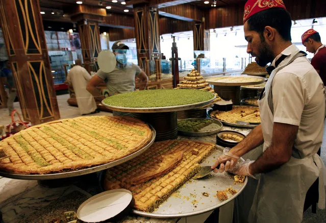 A vendor prepares traditional sweets, during the Muslim fasting month of Ramadan in Baghdad, June 13, 2016. (Photo by Khalid al Mousily/Reuters)