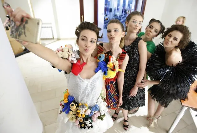 Models take selfie pictures, during an eco-clothing fashion show from recycled materials by French designer Isagus Toche, in Kiev, Ukraine, on 23 June 2017. (Photo by Stepan Franko/EPA/EFE)